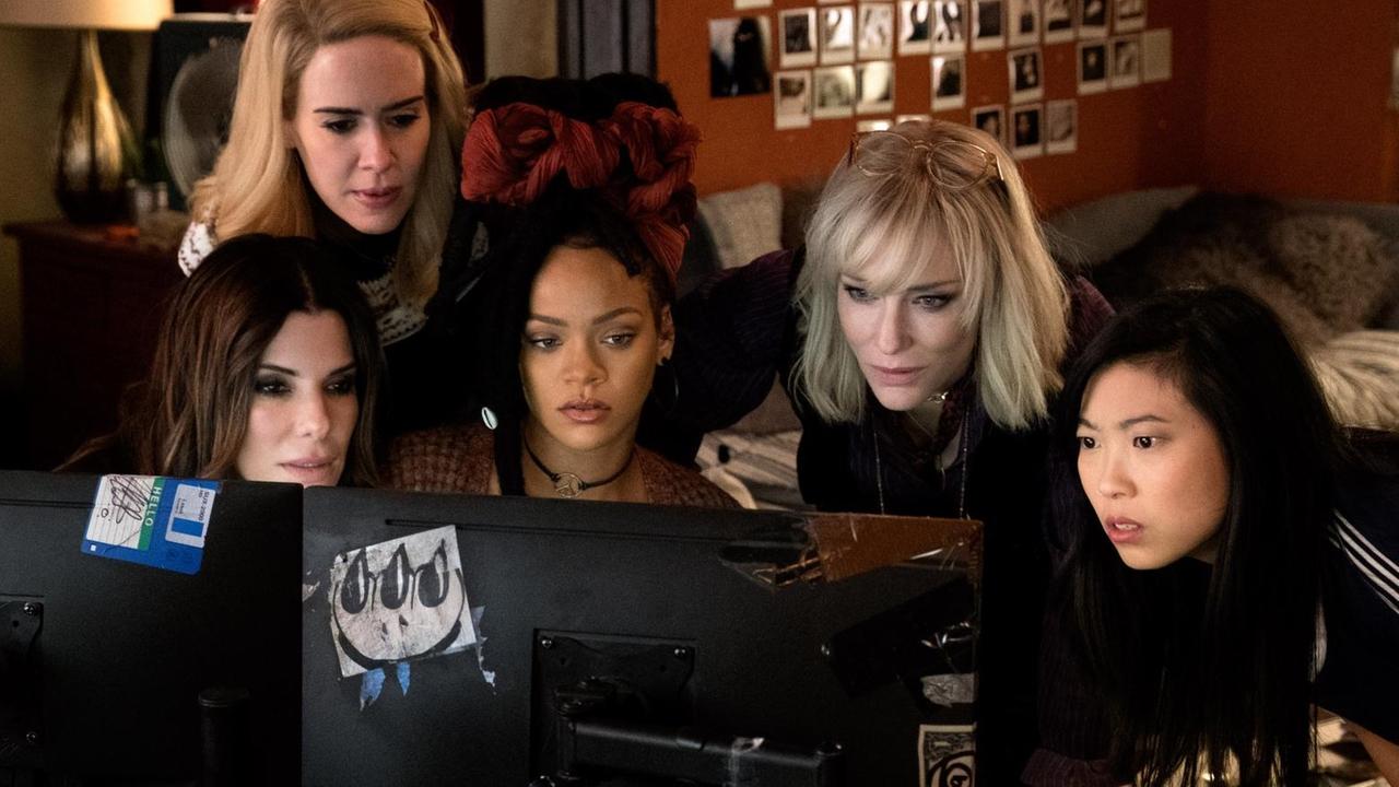 Filmszene aus "Ocean's 8": Sandra Bullock, Sarah Paulson, Rihanna, Cate Blanchett und Awkwafina gruppieren sich um einen Computer. Filmszene aus "Ocean's 8": Sandra Bullock, Sarah Paulson, Rihanna, Cate Blanchett und Awkwafina gruppieren sich um einen Computer.