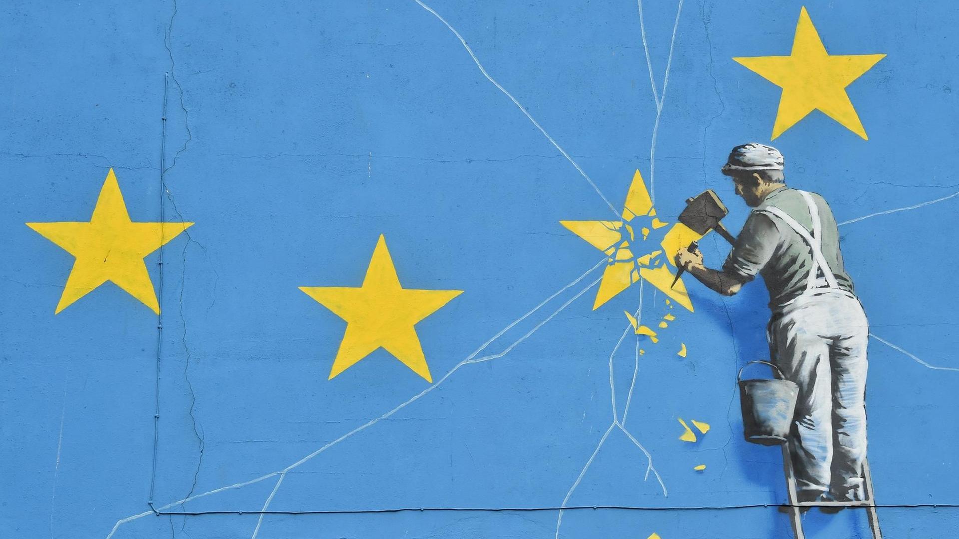 Ein Wandbild von Banksy in der britischen Hafenstadt Dover zeigt eine riesige EU-Flagge und einen Arbeiter, der einen Stern aus der Flagge heraus meißelt.