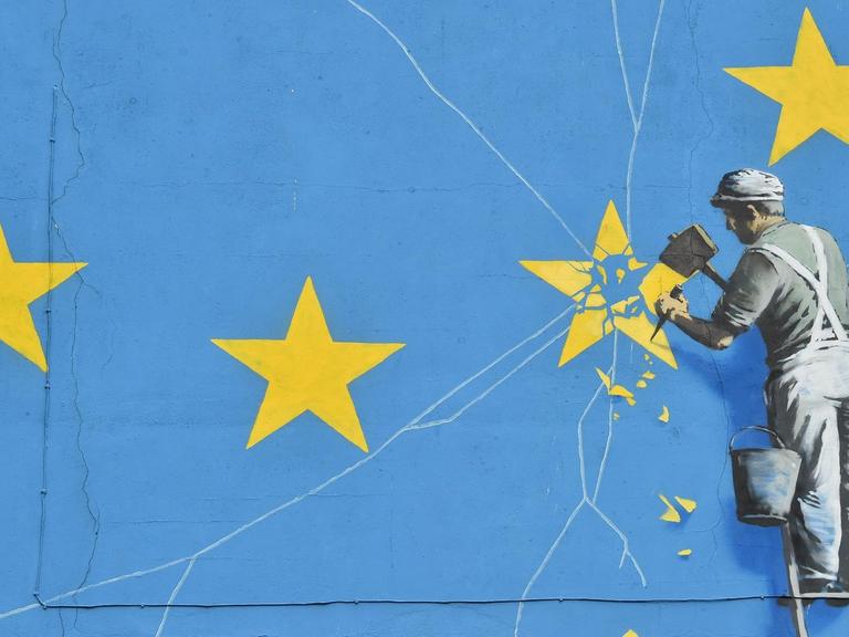 Ein Wandbild von Banksy in der britischen Hafenstadt Dover zeigt eine riesige EU-Flagge und einen Arbeiter, der einen Stern aus der Flagge heraus meißelt.