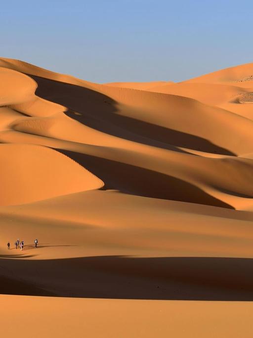 Eine Gruppe von Menschen in den Sanddünen von Moul Naga Tadrart Tassili im Ajjer Nationalpark, Sahara Wüste, Algerien, Afrika