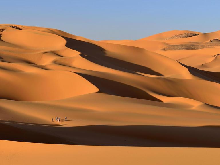 Eine Gruppe von Menschen in den Sanddünen von Moul Naga Tadrart Tassili im Ajjer Nationalpark, Sahara Wüste, Algerien, Afrika