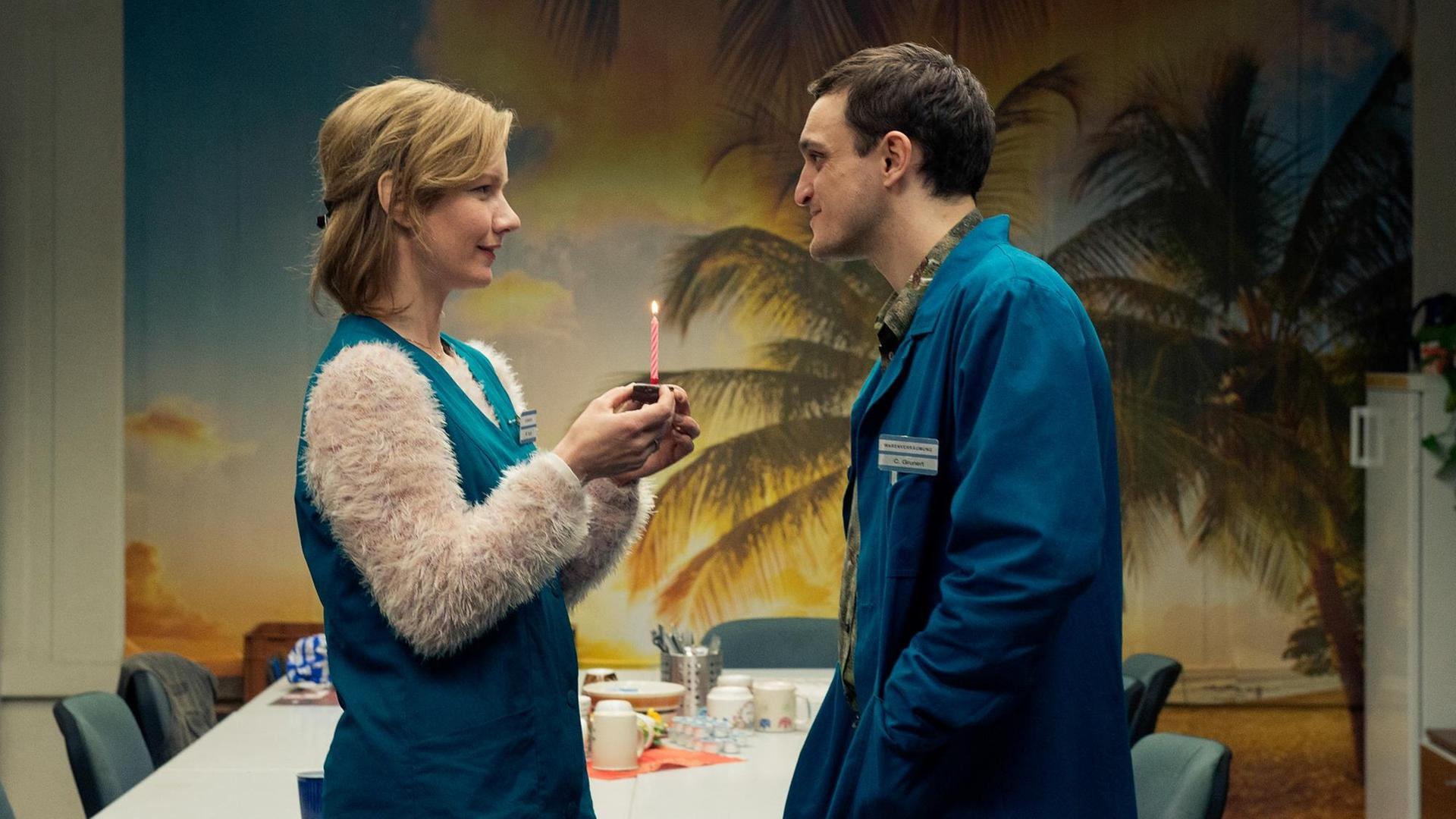Eine Szene aus dem Film "In den Gängen": Christian und Marion treffen sich im Aufenthaltsraum, sie hält eine Kerze hoch.