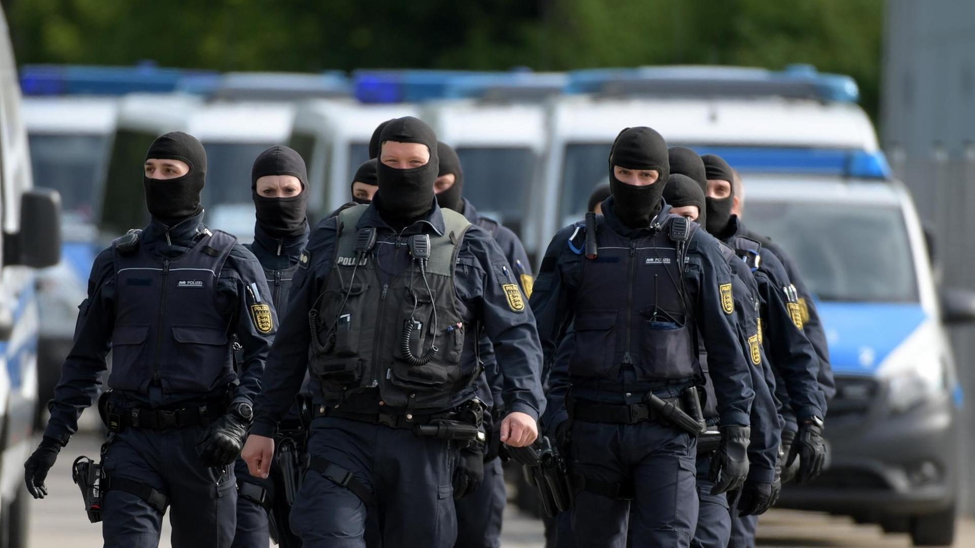 In der Landeserstaufnahmeeinrichtung für Flüchtlinge in Ellwangen gehen maskierte Polizisten.