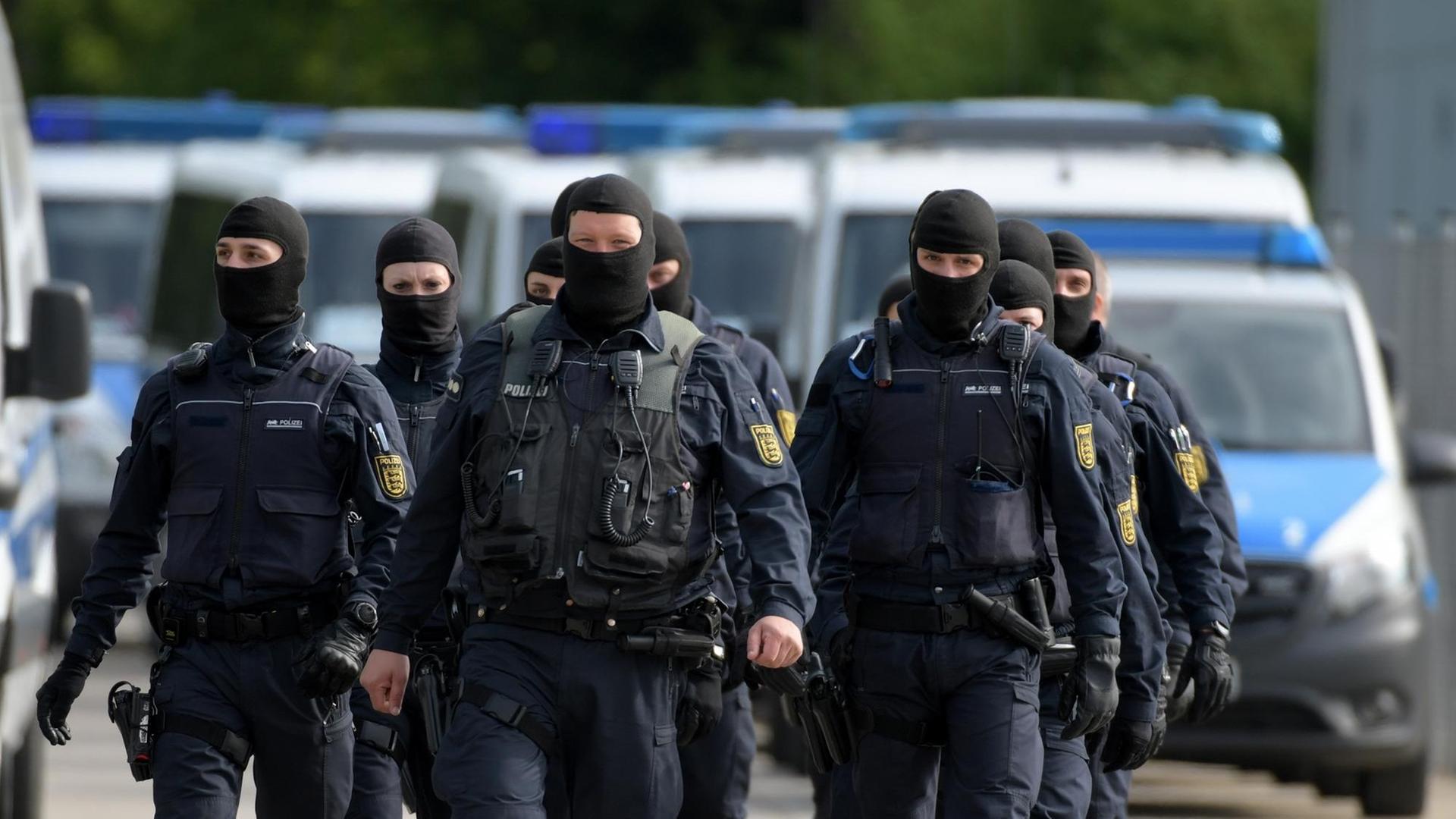 In der Landeserstaufnahmeeinrichtung für Flüchtlinge in Ellwangen gehen maskierte Polizisten. In der Landeserstaufnahmeeinrichtung für Flüchtlinge in Ellwangen gehen maskierte Polizisten.