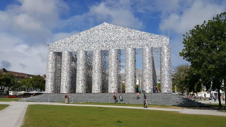 Auf einem Hügel steht ein aus Büchern zusammengesetzter Parthenon nach dem Vorbild des Parthenon auf der Athener Akropolis. Auf einem Hügel steht ein aus Büchern zusammengesetzter Parthenon nach dem Vorbild des Parthenon auf der Athener Akropolis.