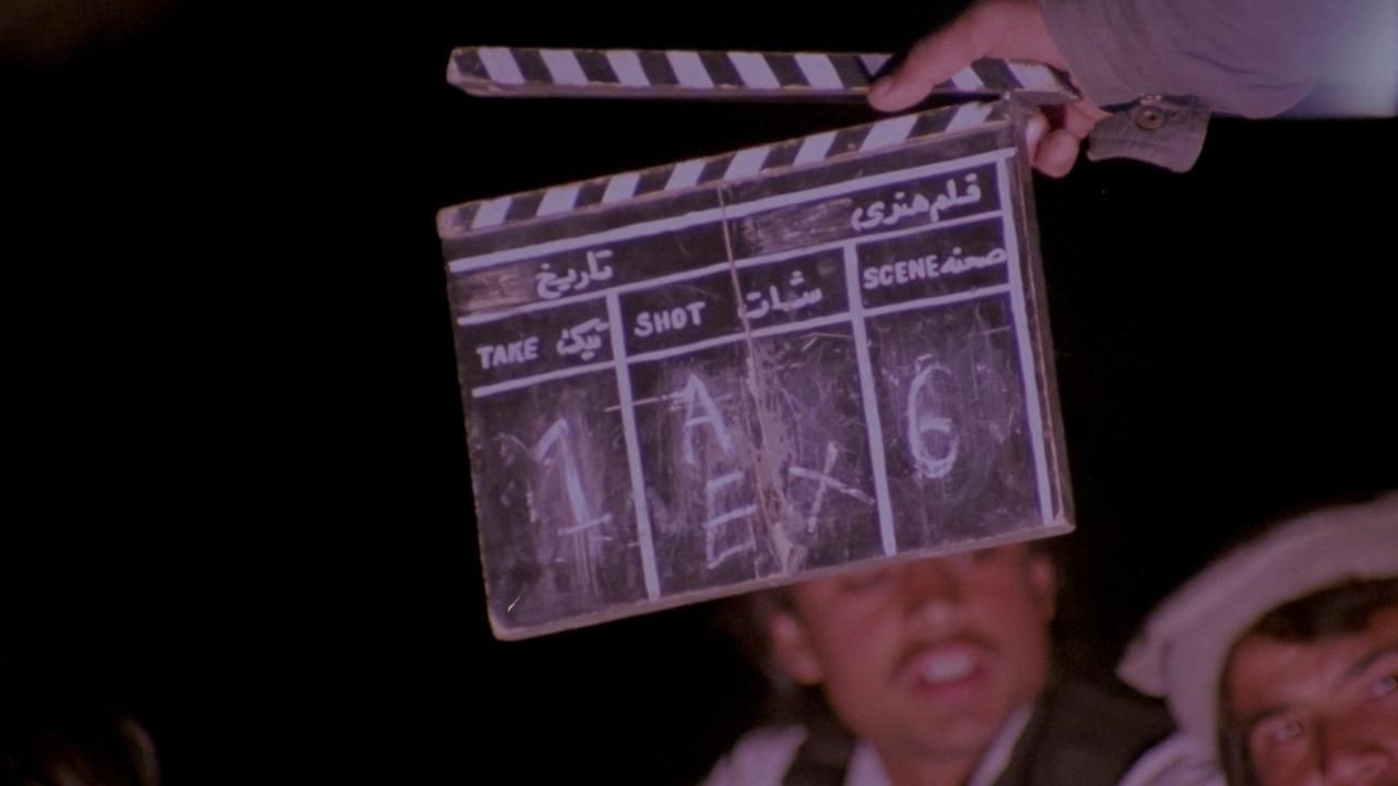 Dreharbeiten zu einem Film. Die Filmklappe ist mitten im Bild und verdeckt das Gesicht eines Schauspielers. Dreharbeiten zu einem Film. Die Filmklappe ist mitten im Bild und verdeckt das Gesicht eines Schauspielers.