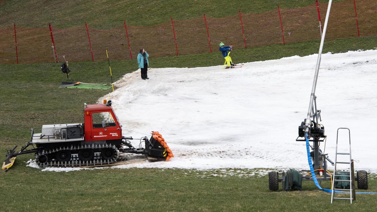 In tieferen Lagen in der Ostschweiz liegt derzeit kaum Schnee. Auf einer grünen Fläche wird deshalb Kunstschnee verteilt. In tieferen Lagen in der Ostschweiz liegt derzeit kaum Schnee. Auf einer grünen Fläche wird deshalb Kunstschnee verteilt.