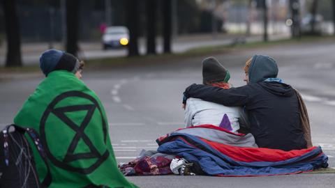 Aktivisten der Klimabewegung "Extinction Rebellion" blockieren sitzend eine Straße in Berlin.
