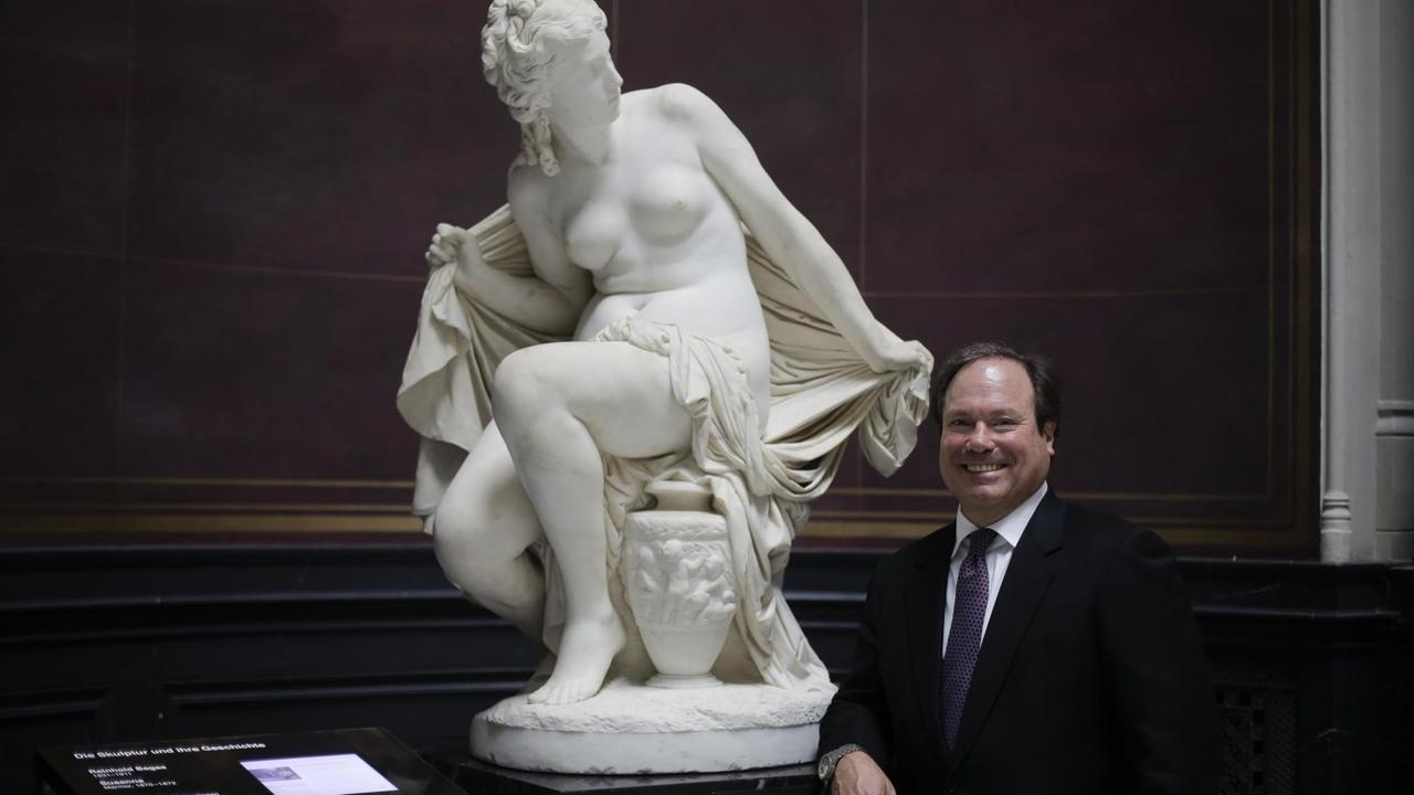 Roger Strauch, Präsident der Mosse-Foundation, steht neben der Skulptur "Susanna" von Reinhold Begas.