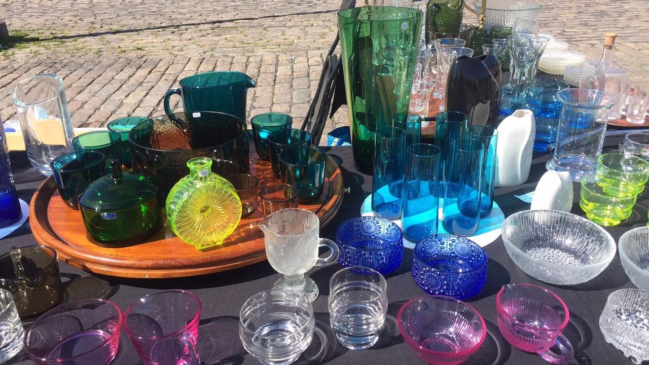 Auf einem Flohmarkt in Helsinki stehen auf einem Tisch Tassen, Teller und Gläser von finnischen Design-Marken.