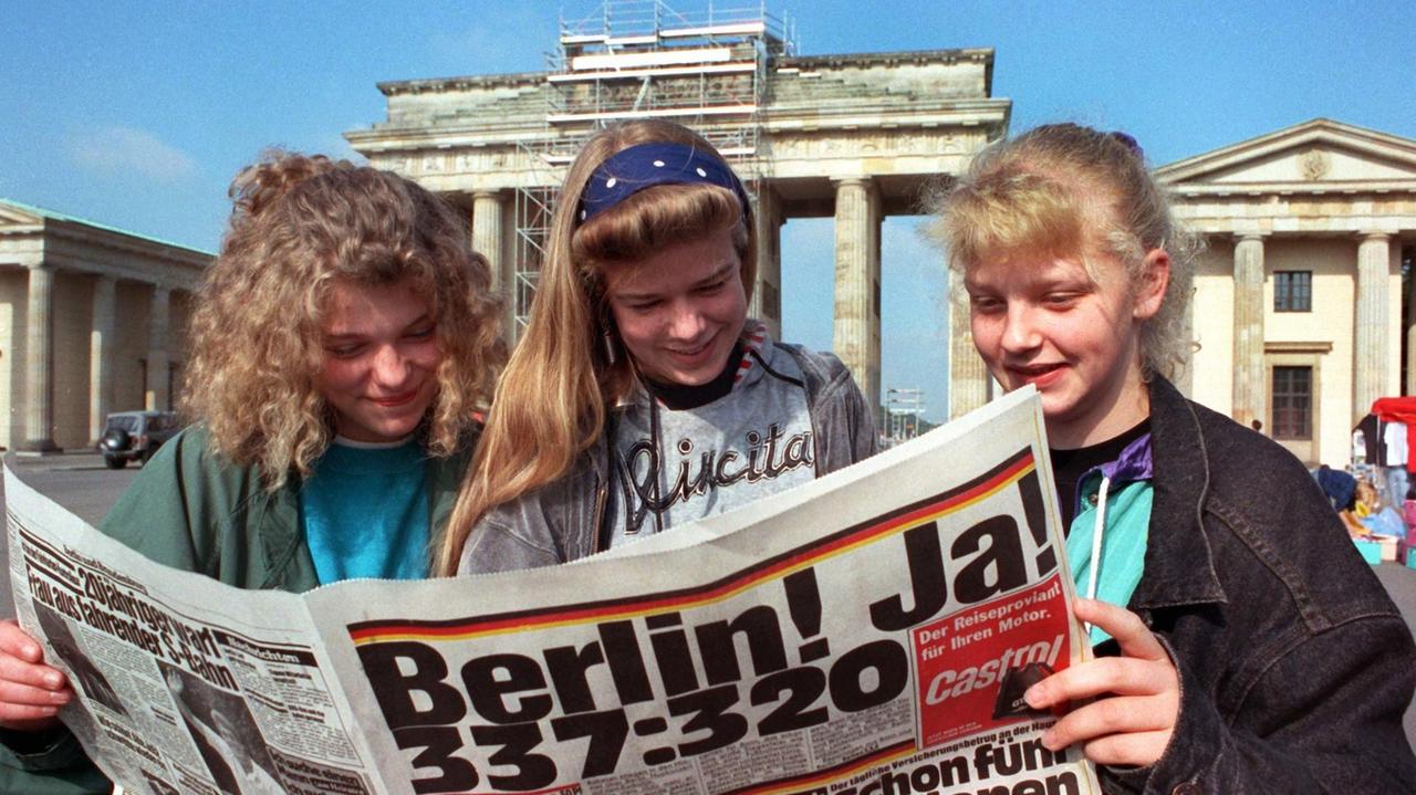 Jugendliche informieren sich am 21. Juni 1991 vor dem Brandenburger Tor aus der Zeitung über das Abstimmungsergebnis zur Entscheidung für Berlin als künftigen Regierungssitz.