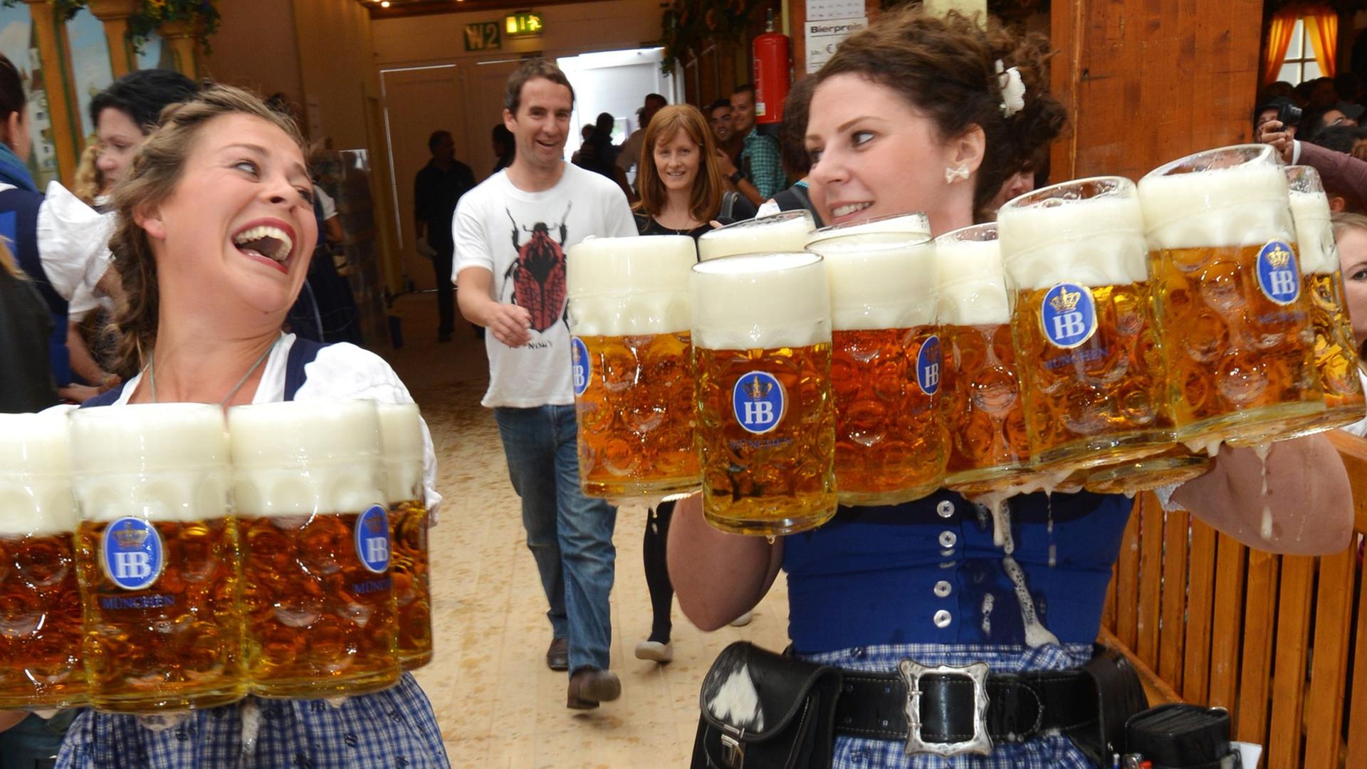 Bedienungen bei der Eröffnung des 180. Oktoberfests am 21.09.2013 in München (Bayern) mit Bierkrügen. Bedienungen bei der Eröffnung des 180. Oktoberfests am 21.09.2013 in München (Bayern) mit Bierkrügen.