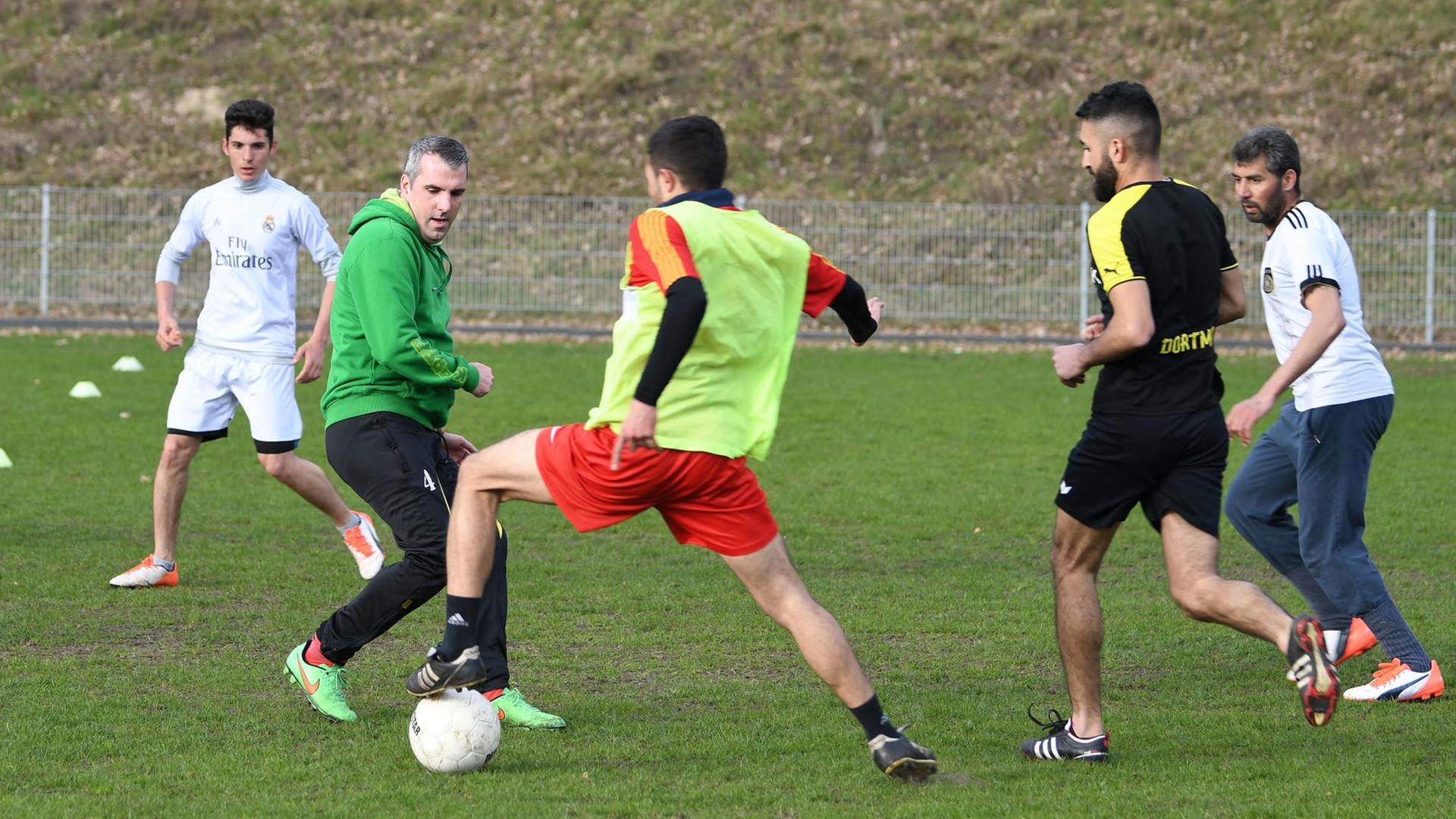 Trainer Ralf Kache (2v.l.) spielt am 06.04.2017 in Lohne (Niedersachsen) mit Flüchtlingen, die sich zum FC Unlimited zusammengeschlossen haben Fußball. Die Spieler des FC Unlimited trainieren vier Mal die Woche. Es sind Flüchtlinge, die unter anderem aus Syrien, dem Irak, Afghanistan, der Ukraine, Eritrea kommen. Trainer Ralf Kache (2v.l.) spielt am 06.04.2017 in Lohne (Niedersachsen) mit Flüchtlingen, die sich zum FC Unlimited zusammengeschlossen haben Fußball. Die Spieler des FC Unlimited trainieren vier Mal die Woche. Es sind Flüchtlinge, die unter anderem aus Syrien, dem Irak, Afghanistan, der Ukraine, Eritrea kommen.