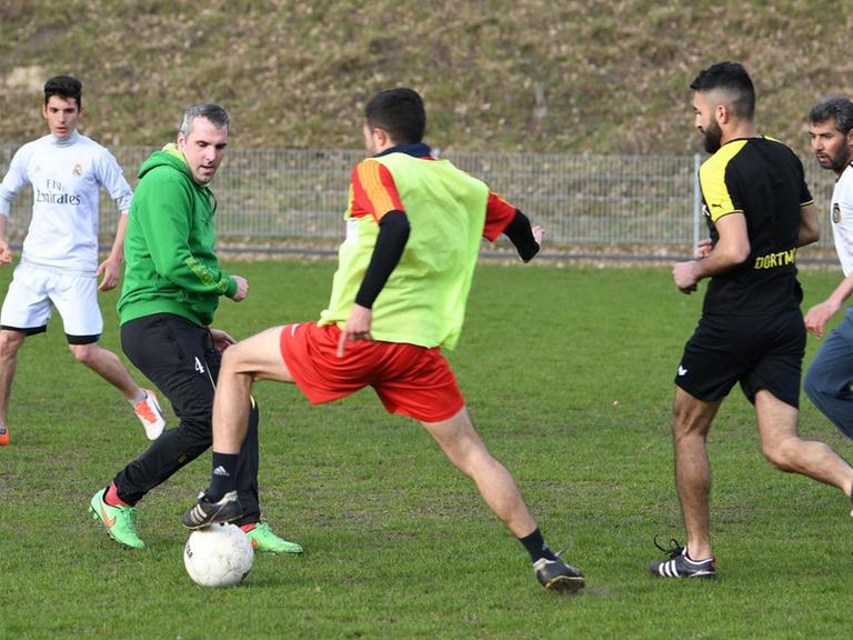 Trainer Ralf Kache (2v.l.) spielt am 06.04.2017 in Lohne (Niedersachsen) mit Flüchtlingen, die sich zum FC Unlimited zusammengeschlossen haben Fußball. Die Spieler des FC Unlimited trainieren vier Mal die Woche. Es sind Flüchtlinge, die unter anderem aus Syrien, dem Irak, Afghanistan, der Ukraine, Eritrea kommen.