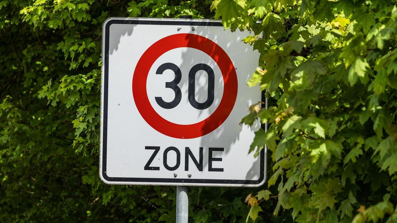 Ein Verkehrsschild, das eine 30er-Zone markiert. Ein Verkehrsschild, das eine 30er-Zone markiert.