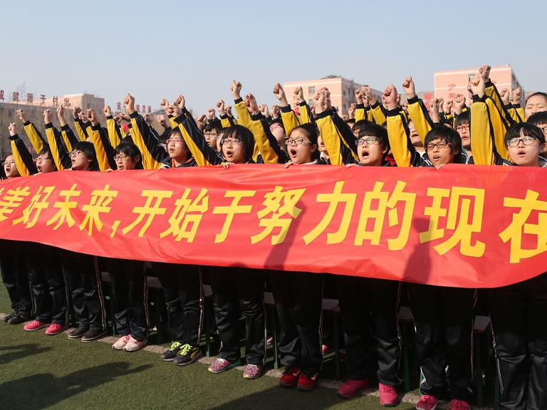Junge Chinesen in der nordchinesischen Hebei-Provinz bei einer Massenveranstaltung zum Gao Kao, der nationalen Abschlussprüfung für den Eintritt ins Studium, aufgenommen am 26.2.2015.