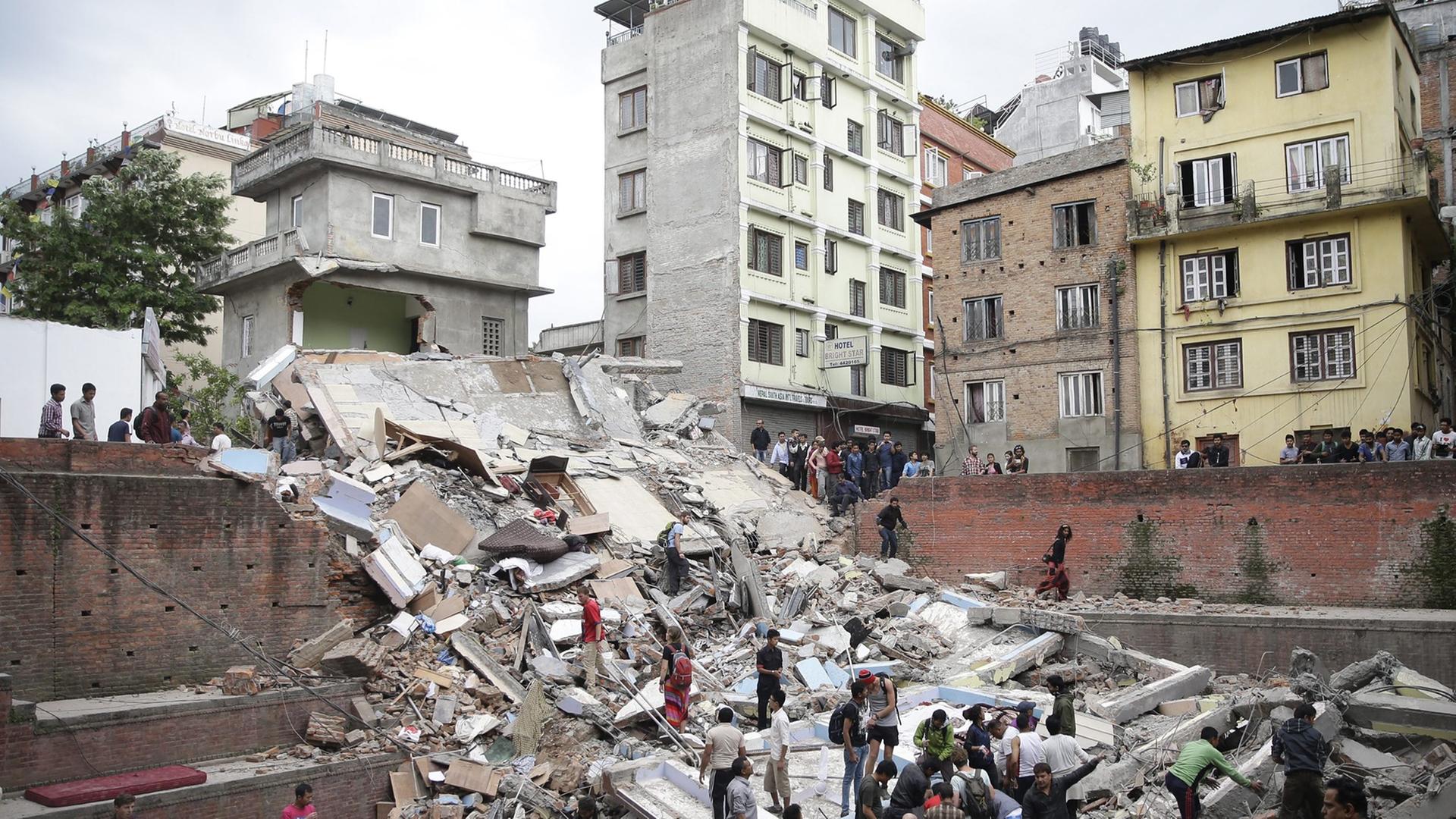 Menschen suchen nach dem Erdbeben mit der Stärke 7,9 in der Hauptstadt Nepals nach Verschütteten.