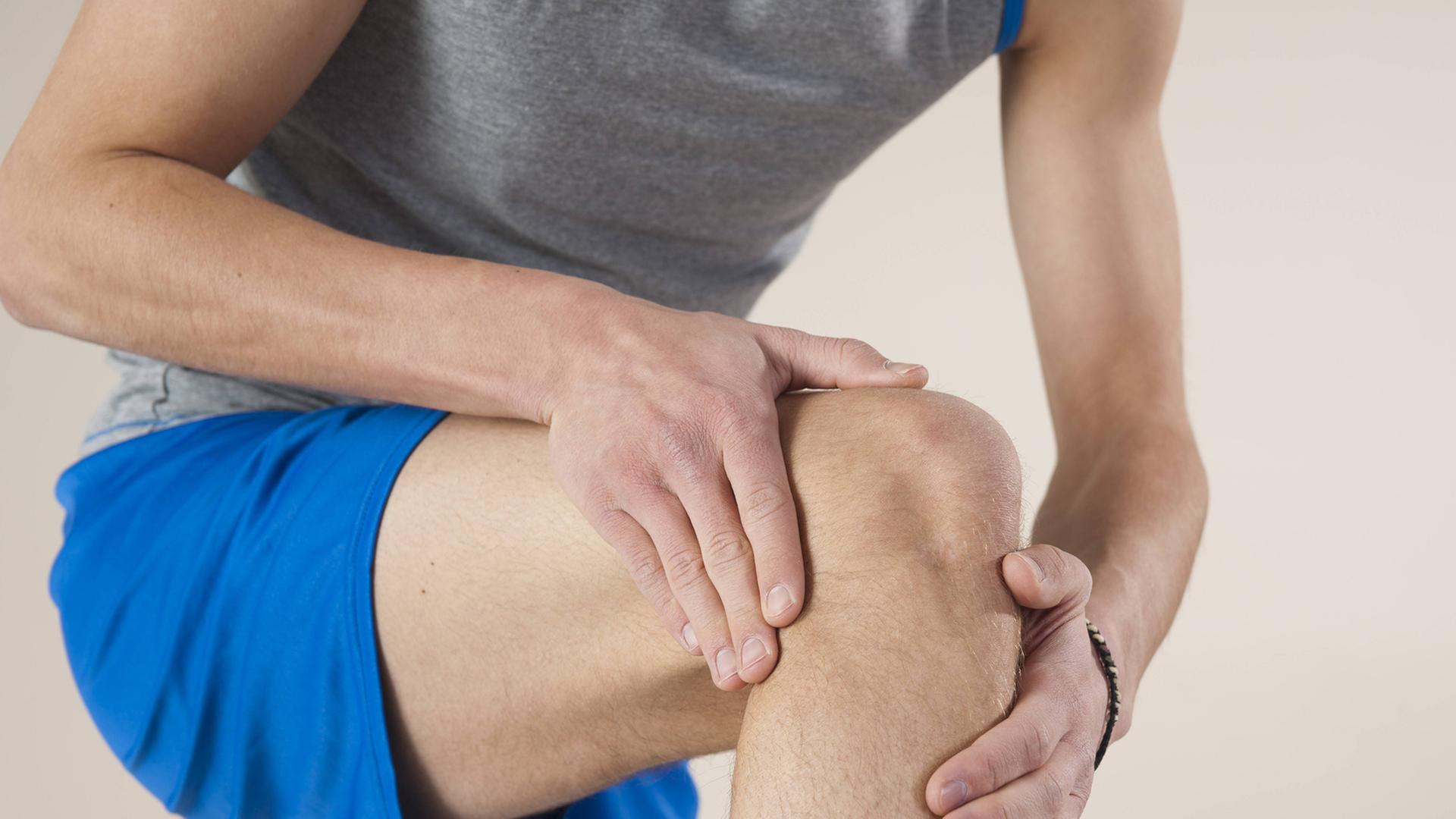 Ein Mann hält sein Knie. Ein Mann hält sein Knie.