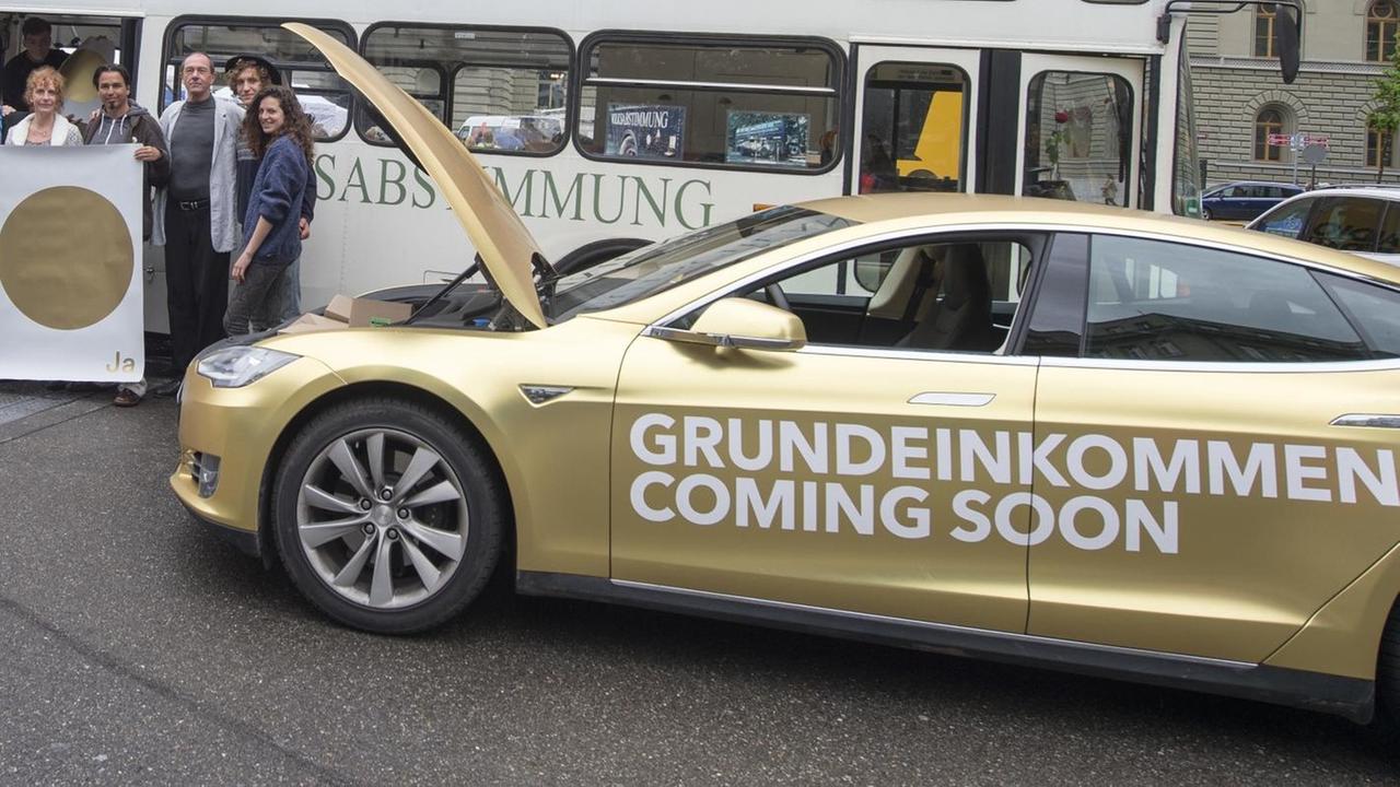 Enno Schmidt und Daniel Häni, Gründer der Volksinitiative "Bedingungslosen Grundeinkommens" mit dem Tesla Werbemobil, und Deutsche Aktivistinnen- und Aktivisten zur Einführung der direkten Demokratie in Deutschland mit ihrem Omnibus, beim Fototermin vor dem Bundeshaus auf dem Bundesplatz in Bern, am 12.05.2016. Enno Schmidt und Daniel Häni, Gründer der Volksinitiative "Bedingungslosen Grundeinkommens" mit dem Tesla Werbemobil, und Deutsche Aktivistinnen- und Aktivisten zur Einführung der direkten Demokratie in Deutschland mit ihrem Omnibus, beim Fototermin vor dem Bundeshaus auf dem Bundesplatz in Bern, am 12.05.2016.