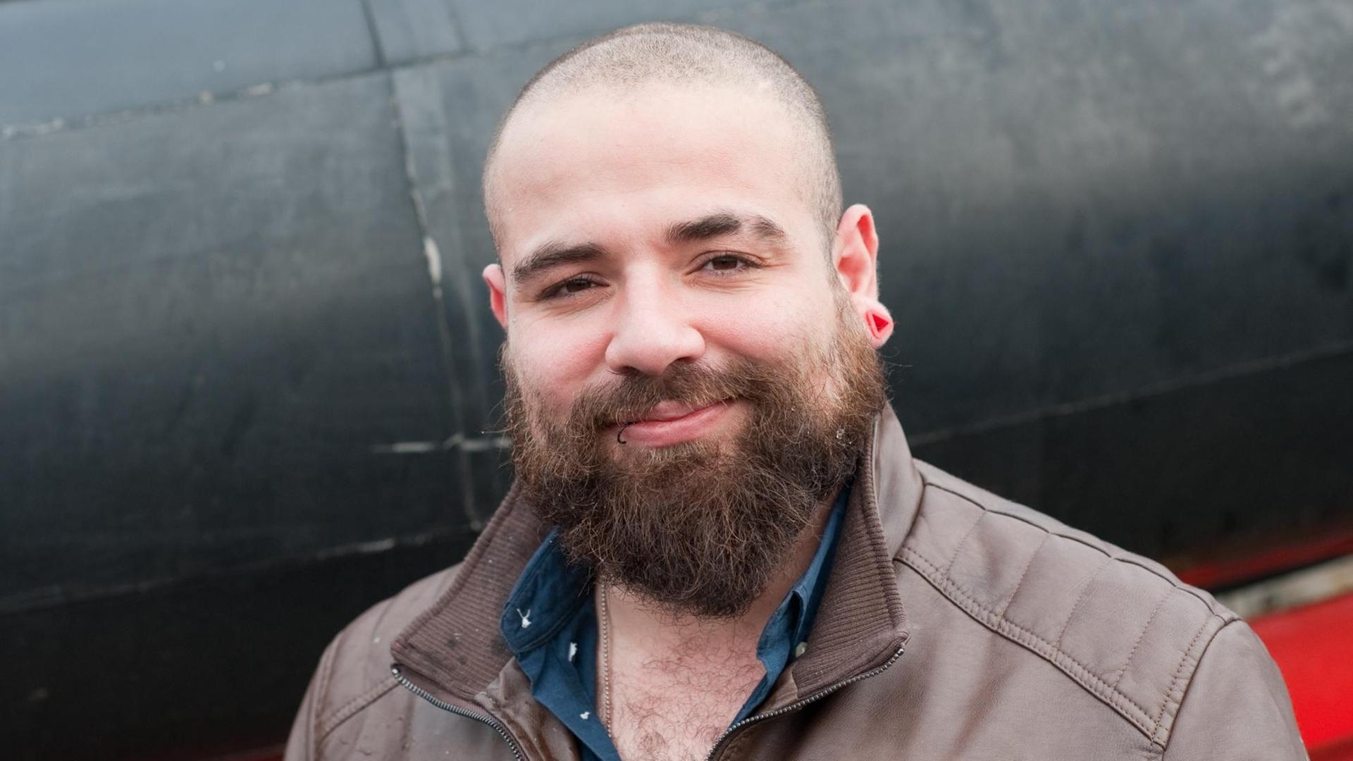 Der aus Syrien geflohene YouTube-Star Firas Alshater steht am 03.03.2016 in Berlin an der Eastside Gallery vor einem neuen Festrumpfschlauchboot Der aus Syrien geflohene YouTube-Star Firas Alshater steht am 03.03.2016 in Berlin an der Eastside Gallery vor einem neuen Festrumpfschlauchboot