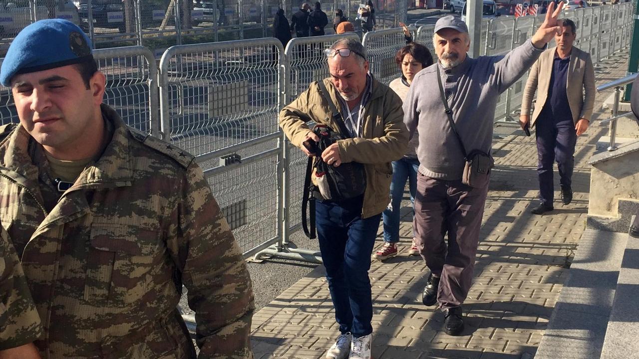 Ali Riza Tolu (2.v.r) zeigt am 11.10.2017 vor dem Gerichtsgebäude in Silivri (Türkei) das Victory-Zeichen. In dem Gebäude begann an diesem Tag der Prozess gegen seine Tochte, die deutsche Journalistin und Übersetzerin Mesale Tolu. Ali Riza Tolu (2.v.r) zeigt am 11.10.2017 vor dem Gerichtsgebäude in Silivri (Türkei) das Victory-Zeichen. In dem Gebäude begann an diesem Tag der Prozess gegen seine Tochte, die deutsche Journalistin und Übersetzerin Mesale Tolu.