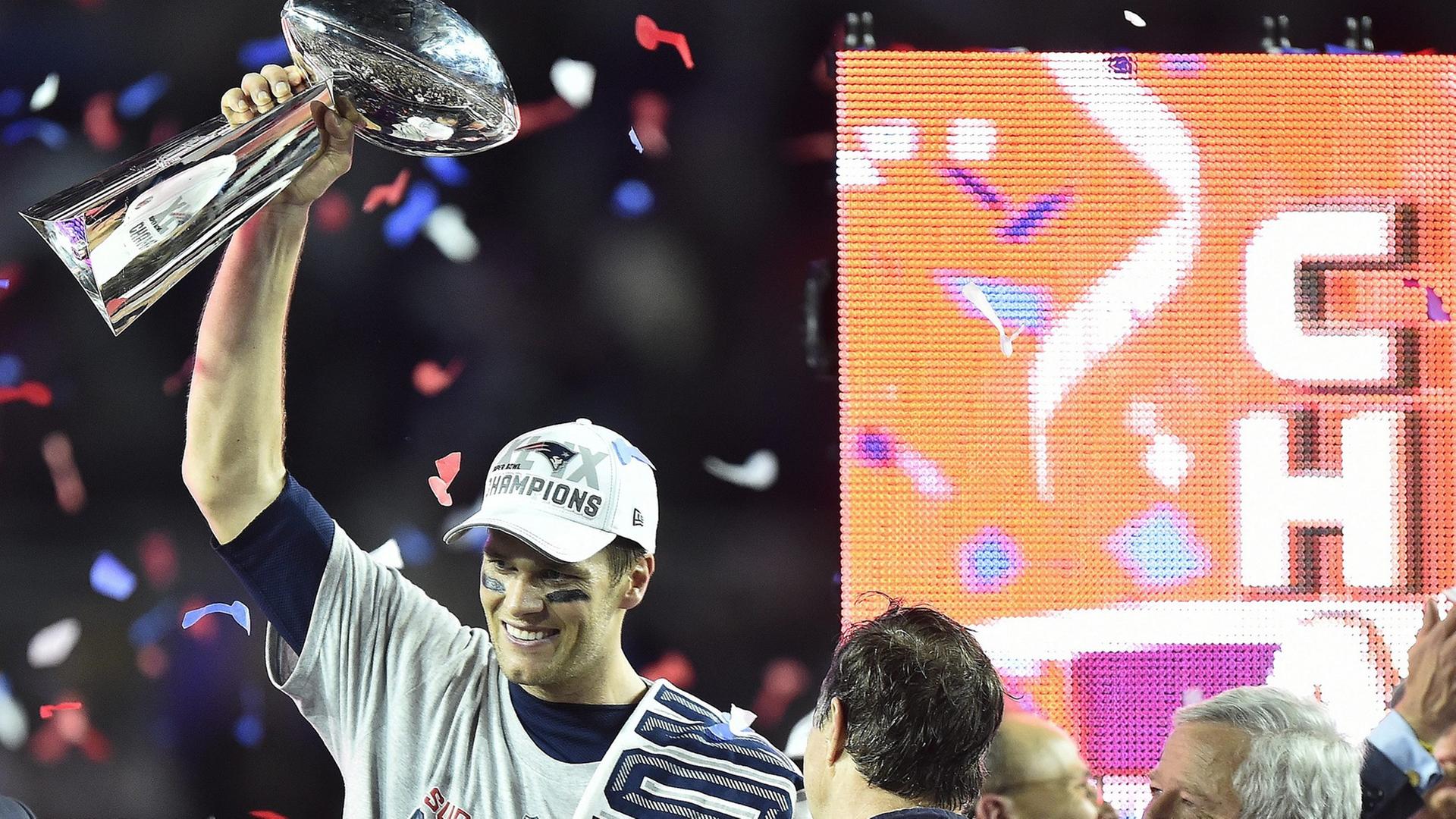 New England Patriots Quarterback Tom Brady hält nach dem Gewinn des Super Bowl die Trophäe in die Höhe.