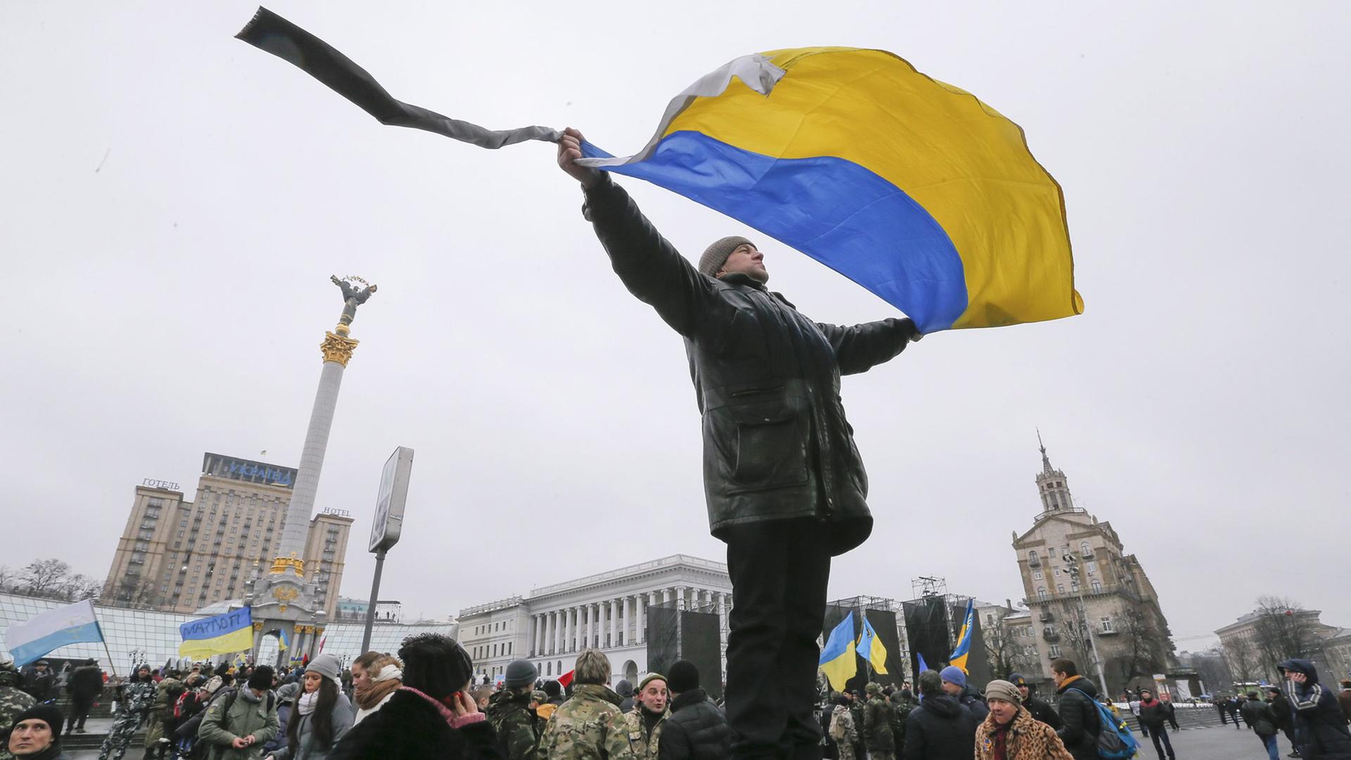 Mann mit ukrainischer Flagge auf dem Maidan in Kiew Mann mit ukrainischer Flagge auf dem Maidan in Kiew