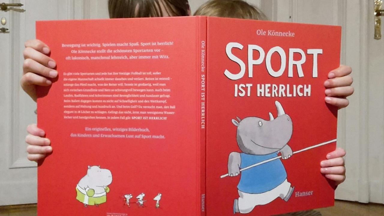 Die Autorin schaut gemeinsamt mit ihrer Tochter in das Bilderbuch "Sport ist herrlich". Die Autorin schaut gemeinsamt mit ihrer Tochter in das Bilderbuch "Sport ist herrlich".