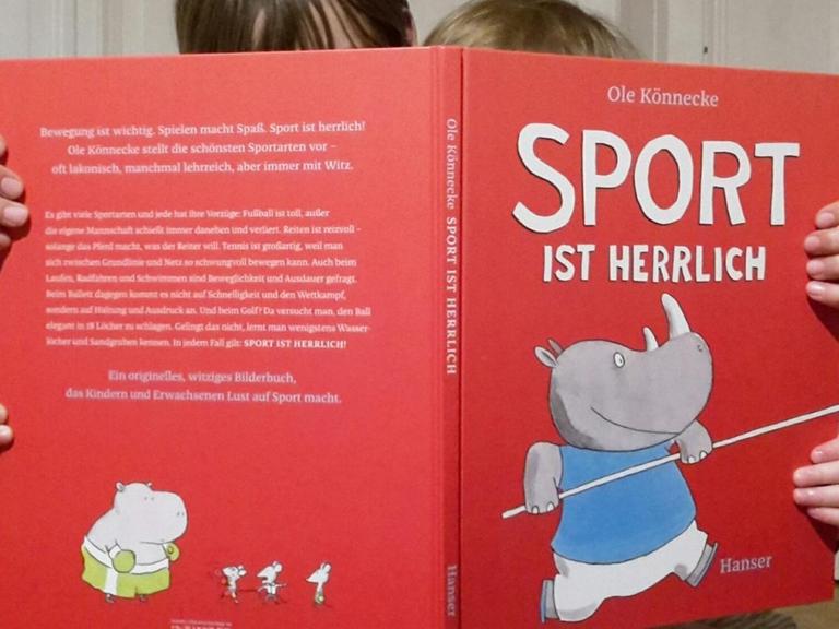 Die Autorin schaut gemeinsamt mit ihrer Tochter in das Bilderbuch "Sport ist herrlich".