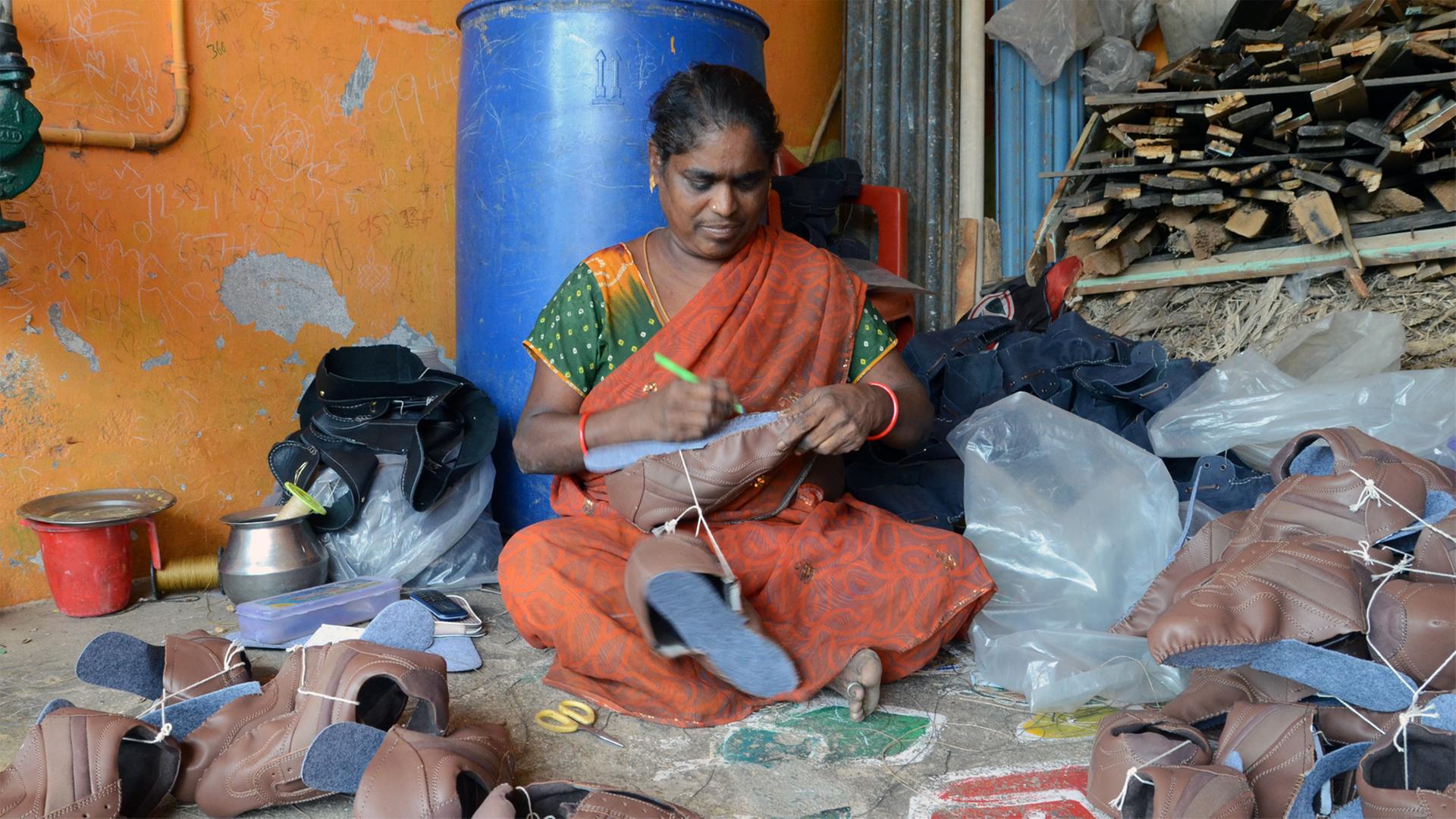 Schuhproduktion in Indien: Die Mittlerin Chinamma kontrolliert die angelieferten Oberteile der Heimarbeiterinnen. Schuhproduktion in Indien: Die Mittlerin Chinamma kontrolliert die angelieferten Oberteile der Heimarbeiterinnen.