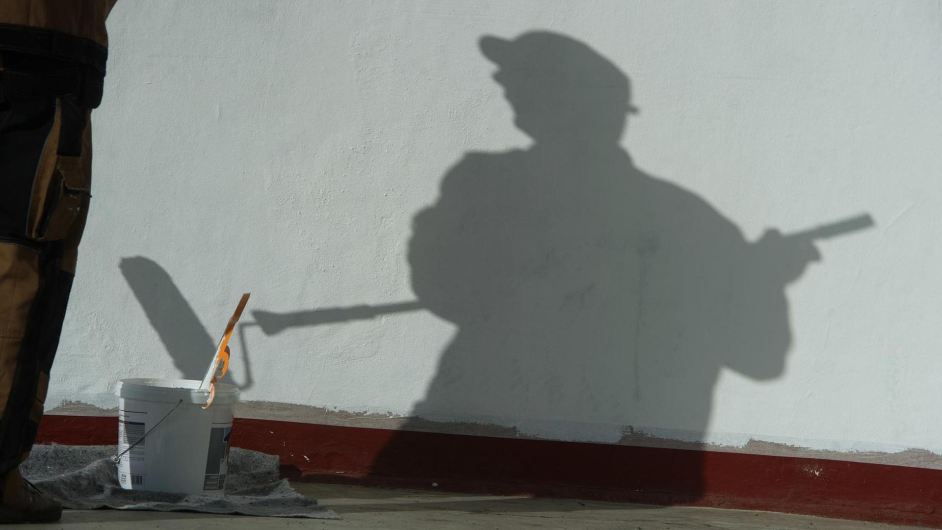 Ein Maler wirft auf einer Baustelle einen Schatten. Ein Maler wirft auf einer Baustelle einen Schatten.