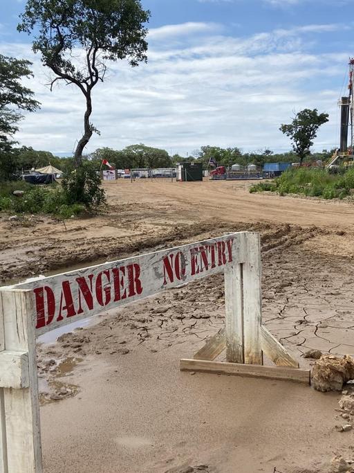 "Danger no entry" steht auf einer Barriere vor dem Bohrloch.