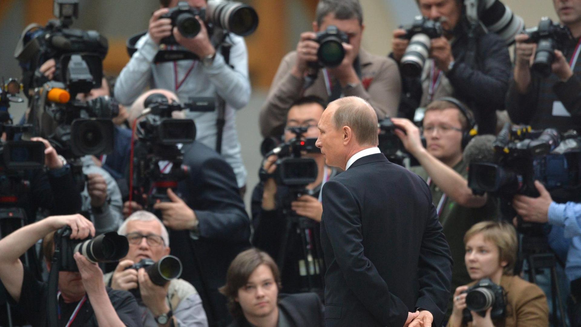 Der russische Präsident Vladimir Putin umrahmt von Fotografen. Der russische Präsident Vladimir Putin umrahmt von Fotografen.