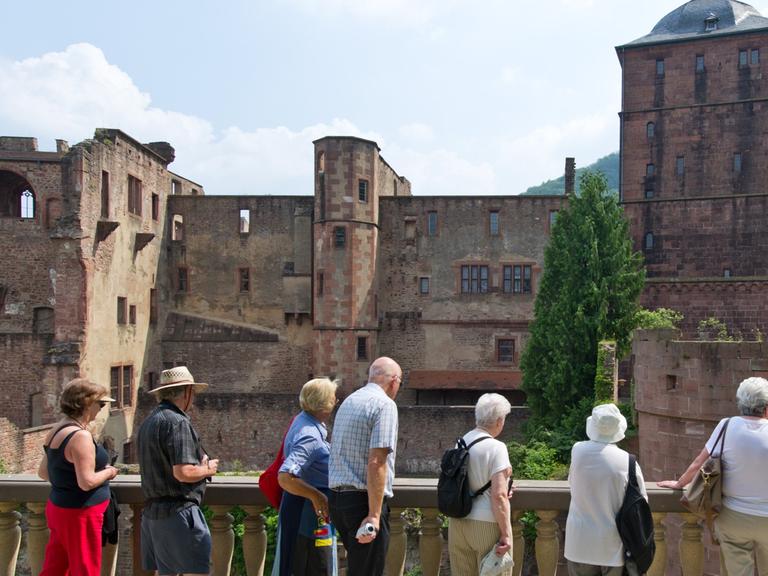 Touristen blicken auf das Heidelberger Schloss.