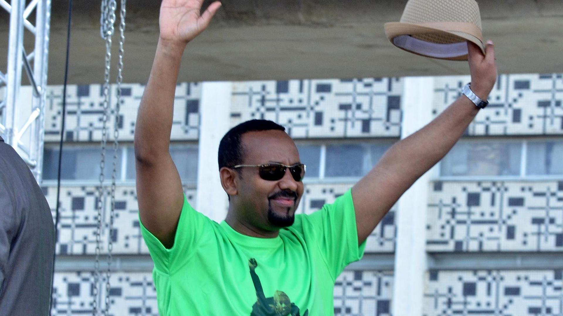 Äthiopiens im April vereidigter Premierminister mit knallgrünem T-Shirt, Sonnenbrille und Hut in der Hand vor der Menschenmenge am 23. Juni 2018 in Addis Abeba