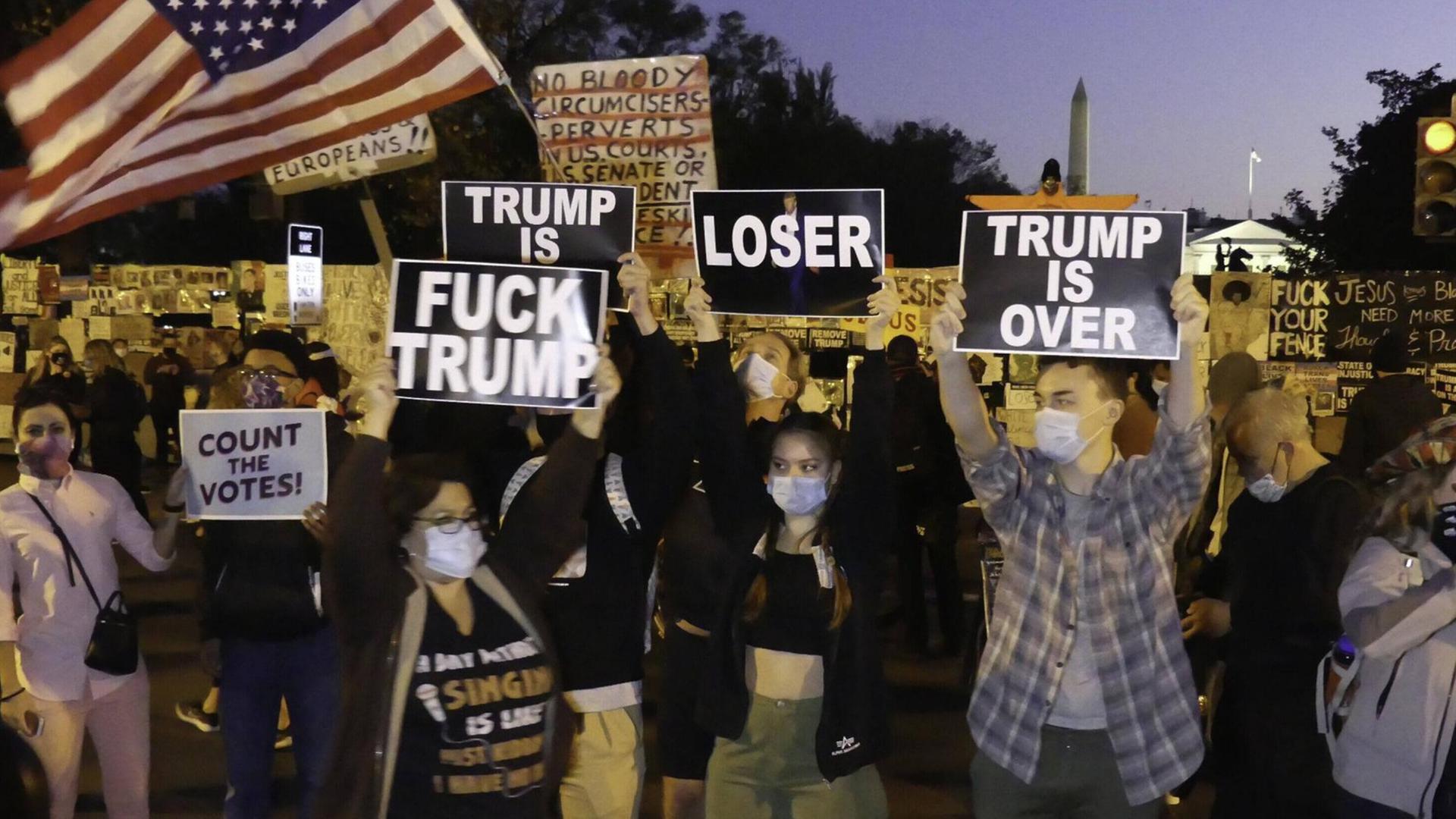 Eine Gruppe von Menschen demonstriert vor dem Weißen Haus gegen Donald Trump. Eine Gruppe von Menschen demonstriert vor dem Weißen Haus gegen Donald Trump.