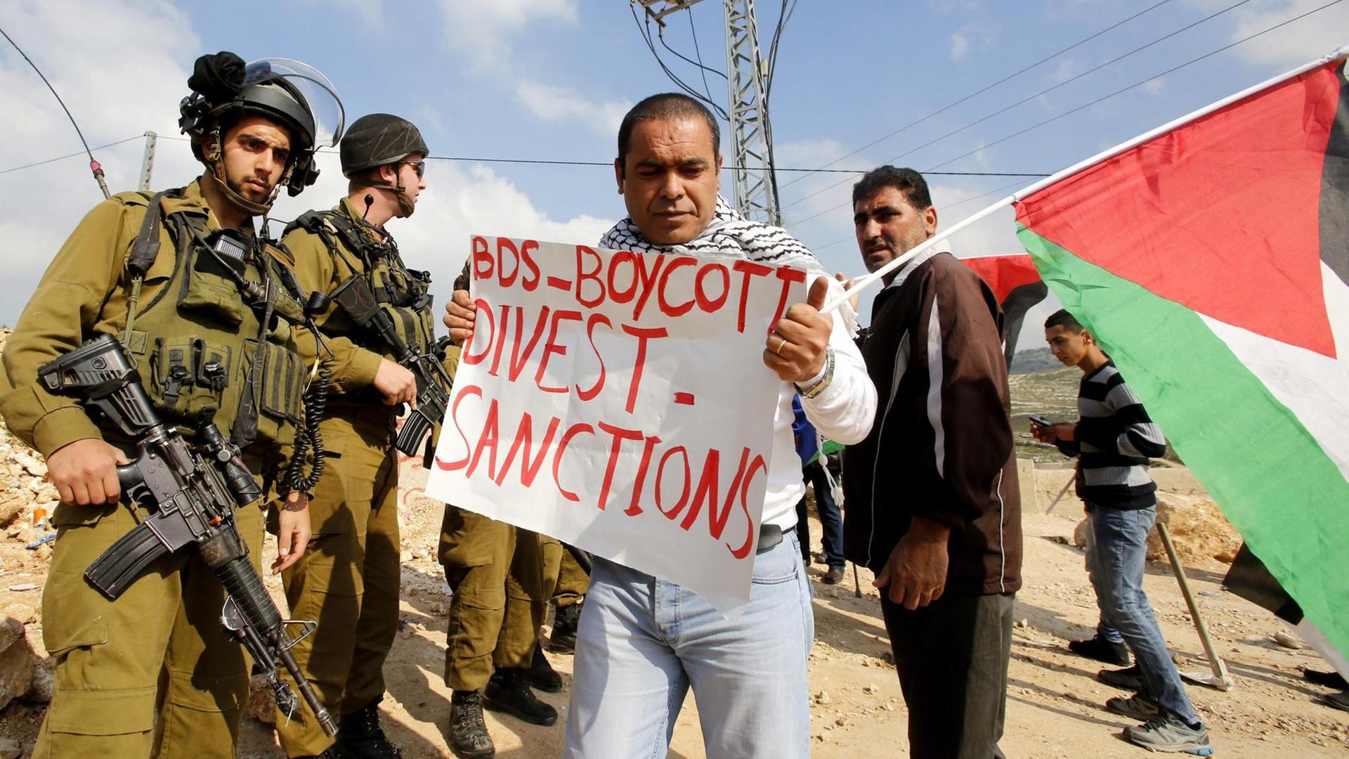 Palästinensische Demonstranten mit Plakate, die sich auf die BDS-Bewegung (Boycott, Divestment and Sanctions) beziehen. Palästinensische Demonstranten mit Plakate, die sich auf die BDS-Bewegung (Boycott, Divestment and Sanctions) beziehen.