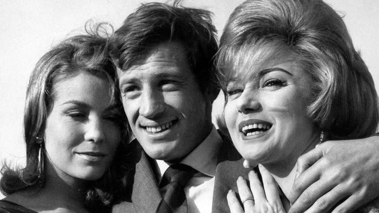 Immer von schönen Frauen umgeben: Frankreichs Schauspielstar Jean- Paul Belmondo posiert am 30.5.1960 in Paris zwischen seinen Filmpartnerinnen.