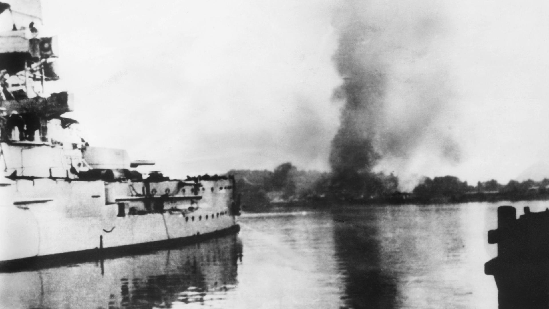 Das im Hafenkanal von Neufahrwasser (Danzig) liegende deutsche Linienschiff "SMS Schleswig-Holstein" nimmt am 01.09.1939 das auf der Westerplatte liegende polnische Munitionslager unter Beschuss Das im Hafenkanal von Neufahrwasser (Danzig) liegende deutsche Linienschiff "SMS Schleswig-Holstein" nimmt am 01.09.1939 das auf der Westerplatte liegende polnische Munitionslager unter Beschuss