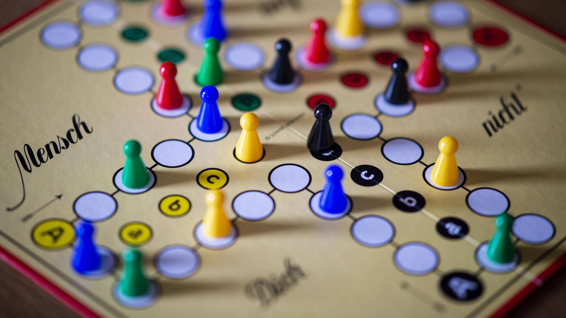 Das Brettspiel "Mensch, ärgere dich nicht" mit verschiedenfarbigen Figuren aufgebaut Das Brettspiel "Mensch, ärgere dich nicht" mit verschiedenfarbigen Figuren aufgebaut