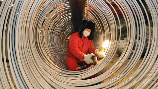 Ein Arbeiter poliert in einem Stahlwerk in Dalian im Nordosten Chinas Edelstahl.
