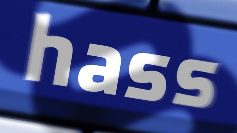 Eine Computertaste mit der Aufschrift "hass" und dem Schatten eines Paragraphen-Zeichens darüber