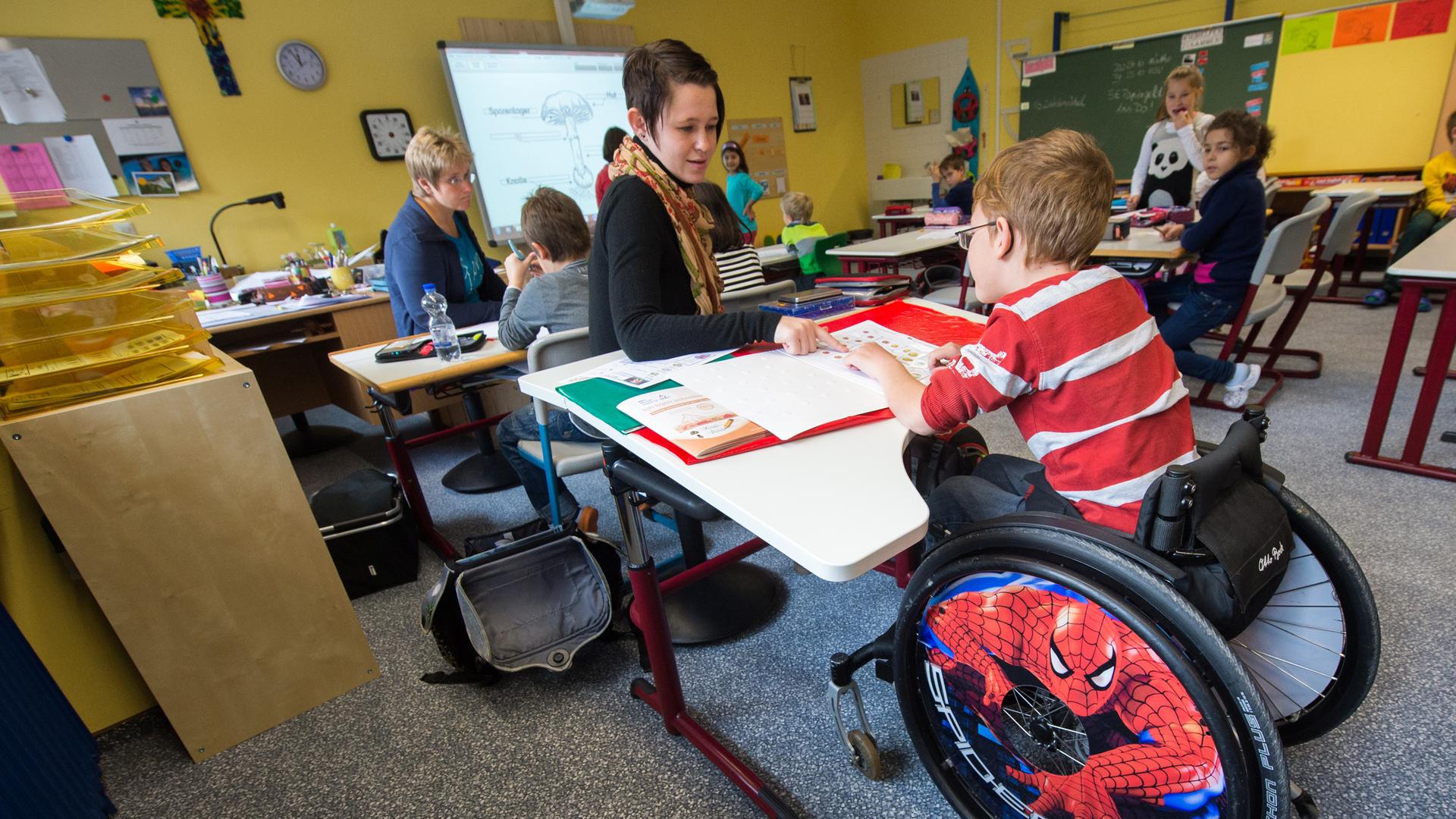 In einer Schul-Klasse sitzt ein Junge im Rollstuhl. In einer Schul-Klasse sitzt ein Junge im Rollstuhl.