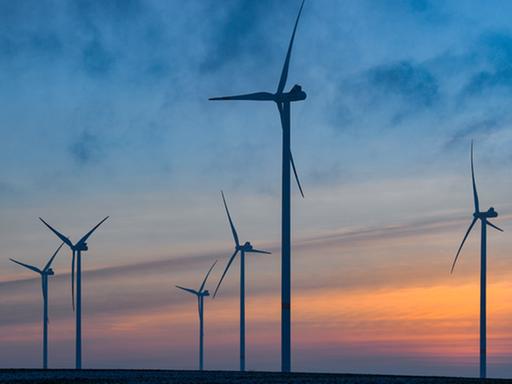 Brandenburg, Jacobsdorf: Windenergieanlagen im Windenergiepark «Odervorland» im Landkreis Oder-Spree sind vor dem Sonnenuntergang zu sehen.