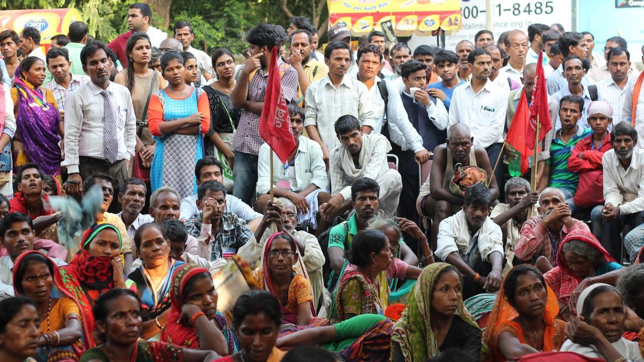 In Indiens Hauptstadt protestieren Anti-Aadhaar-Demonstranten aus ländlichen Regionen. Viele sitzen oder stehen nebeneinander und gucken auf die Bühne.