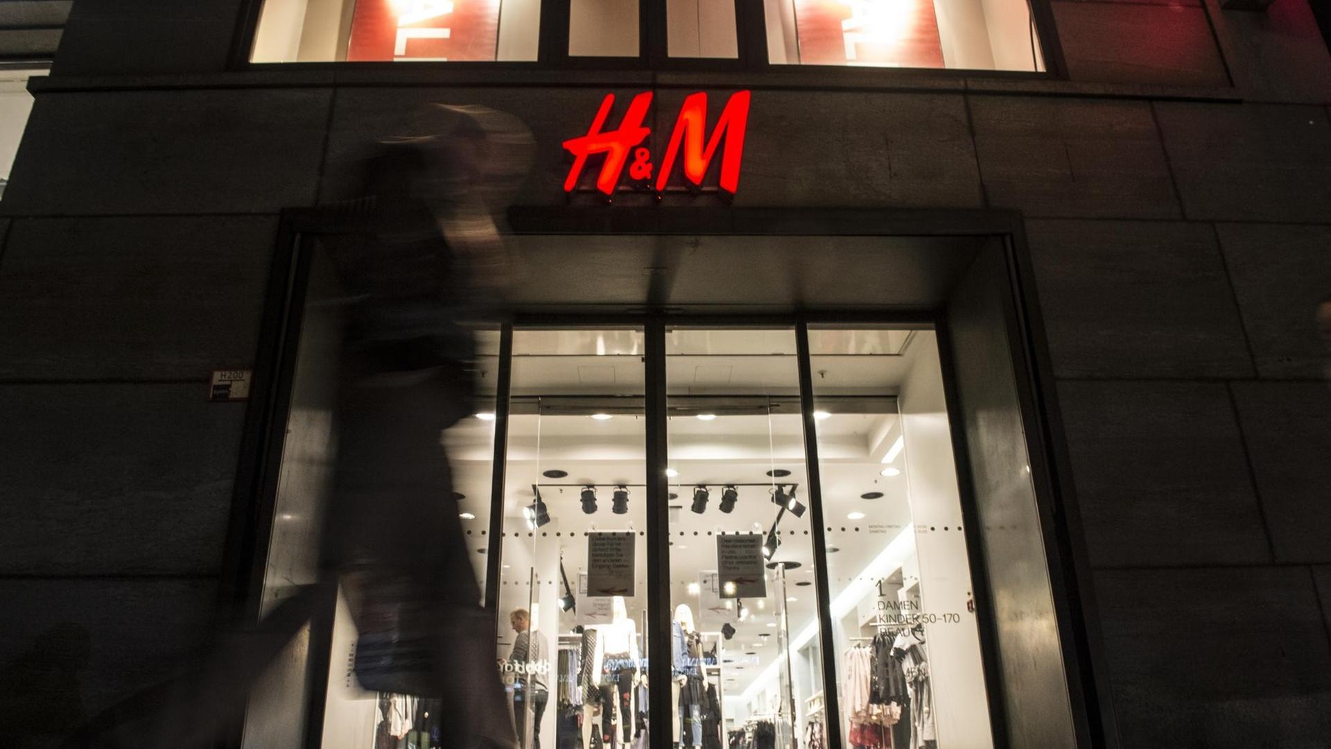 Passanten gehen am 01.02.2017 in Berlin am Abend an einer Filiale der schwedischen Modekette H&M (Hennes & Mauritz) vorbei. Passanten gehen am 01.02.2017 in Berlin am Abend an einer Filiale der schwedischen Modekette H&M (Hennes & Mauritz) vorbei.