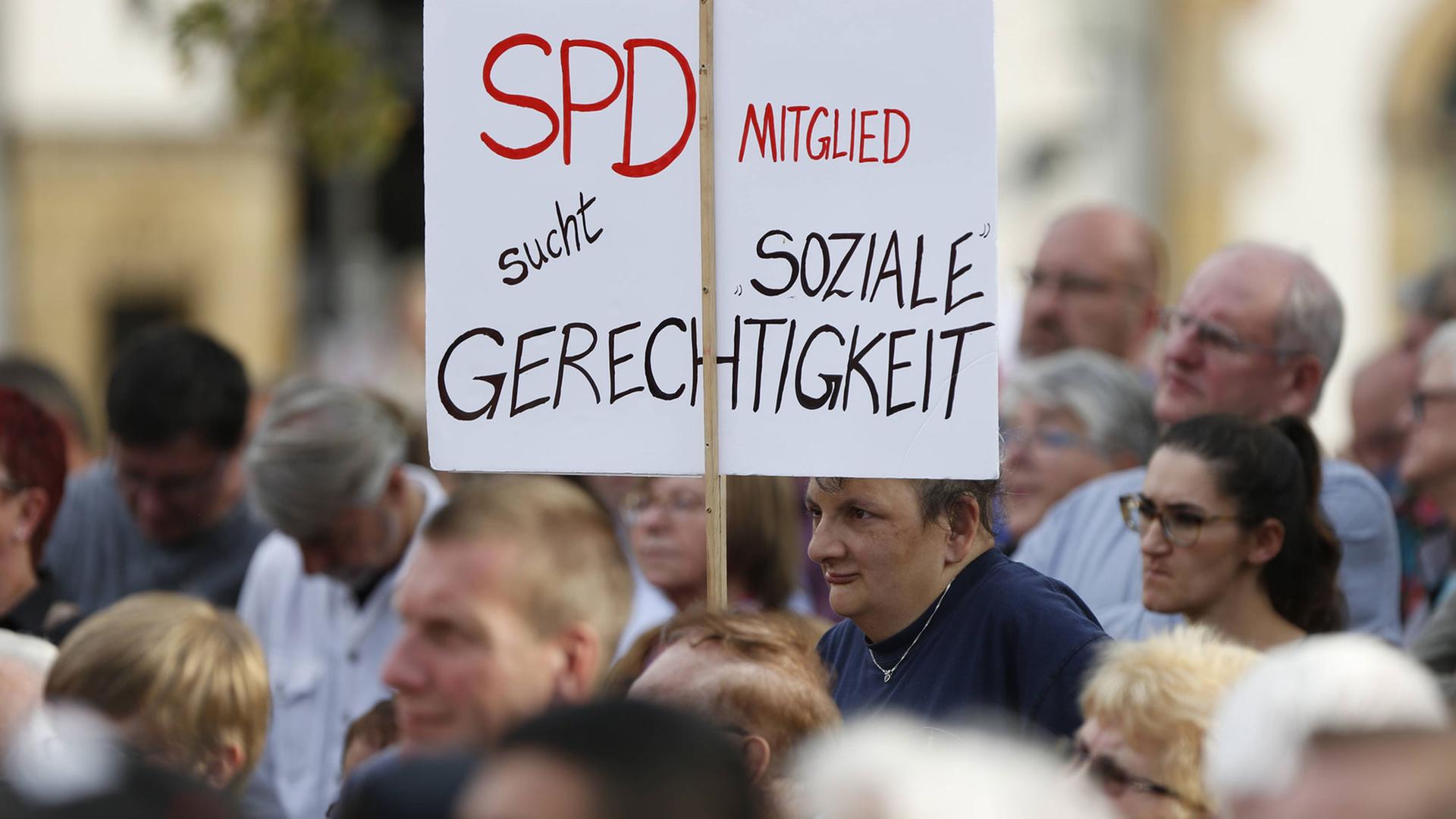 Bei einer Veranstaltung hält ein Zuschauer ein Transparent hoch: "SPD-Mitglied sucht soziale Gerechtigkeit" Bei einer Veranstaltung hält ein Zuschauer ein Transparent hoch: "SPD-Mitglied sucht soziale Gerechtigkeit"