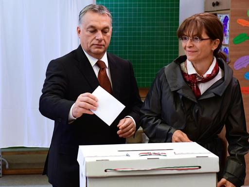 Der ungarische Minister-Präsident Viktor Orban und seine Frau geben werfen ihre Stimm-Zettel ein.