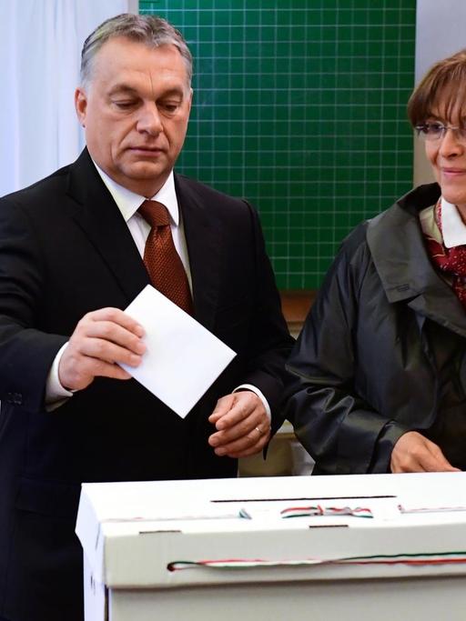 Der ungarische Minister-Präsident Viktor Orban und seine Frau geben werfen ihre Stimm-Zettel ein.