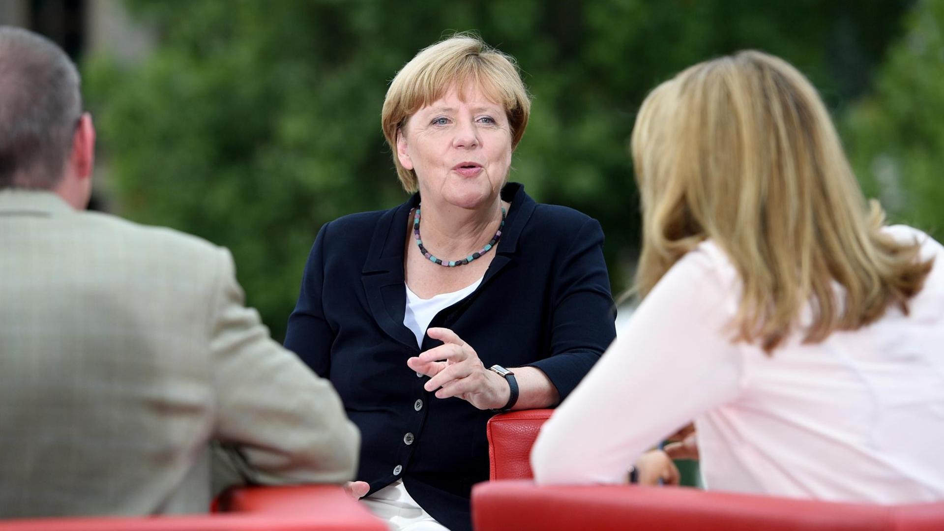Bundeskanzlerin Angela Merkel (M, CDU) wird am 28.08.2016 auf einer Empore des Elisabeth-Lüders-Hauses in Berlin von den ARD-Moderatoren Tina Hassel und Thomas Baumann befragt.